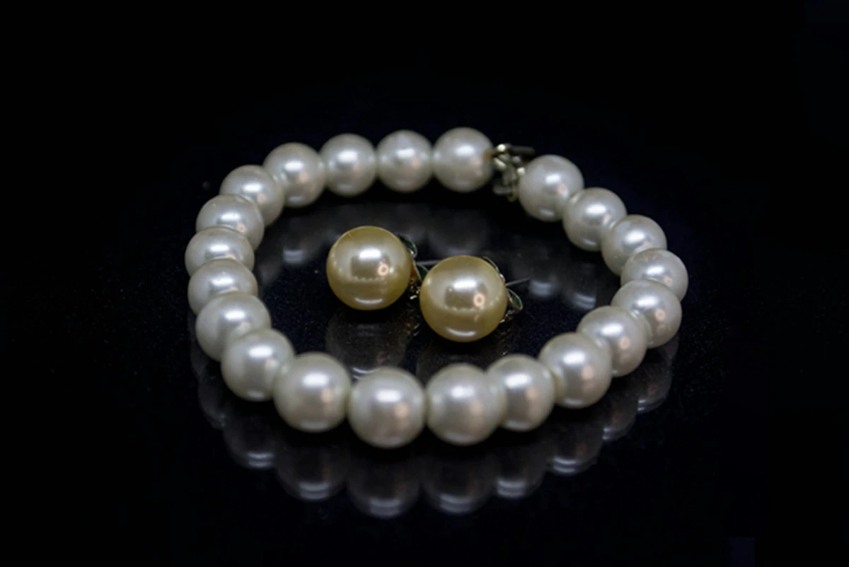 Pearl bracelet with matching stud earrings on black