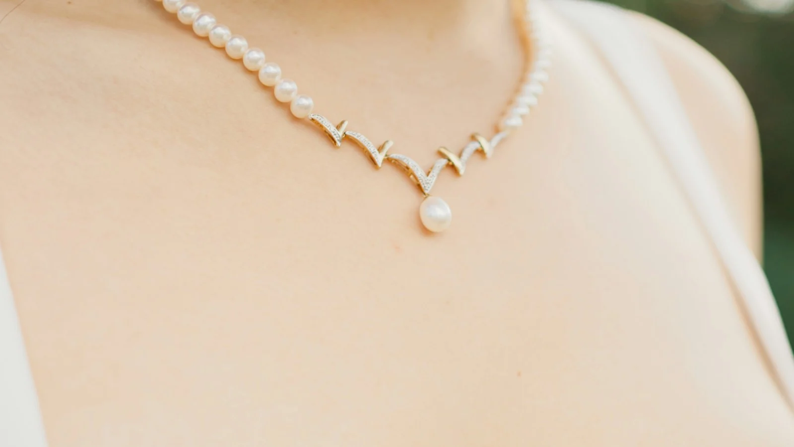Pearl necklace with a single drop pearl worn at the neckline