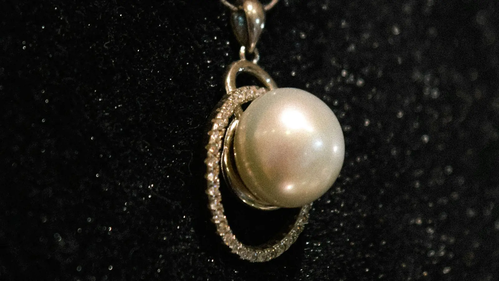 Large pearl pendant set in a gold and diamond halo