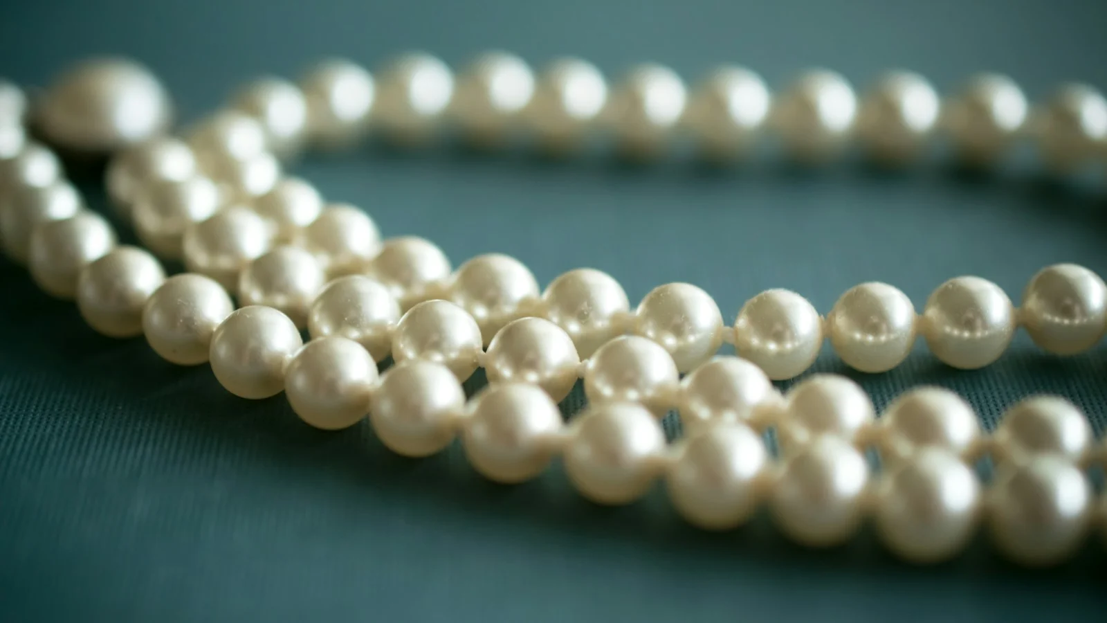White pearl necklace laid on textile for inspection