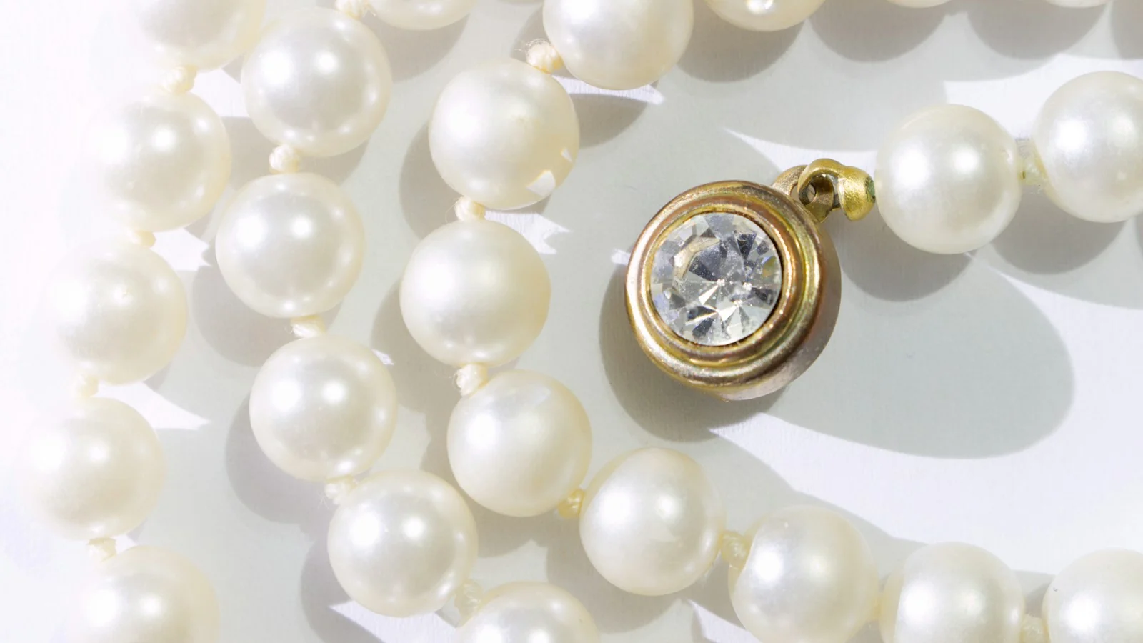 Close-up of white pearls with a gold-set pendant